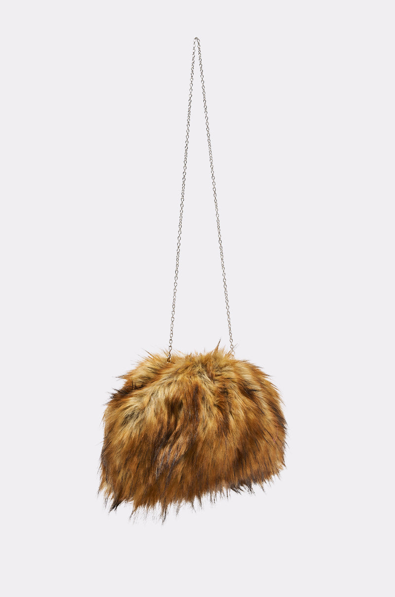 The WILD CHILD FAUX FUR CLUTCH, in brown and black faux fur, hangs against a plain light background and features a long, delicate chain link strap for an elegant touch.