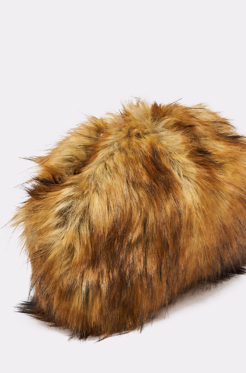 The WILD CHILD FAUX FUR CLUTCH is a rectangular bag with shaggy, brown and black faux fur resembling animal fur, displayed against a plain white background.