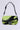 The WILD DREAMS ZEBRA FAUX FUR PURSE is a handbag featuring lime green and black zebra faux fur, a top strap, and silver buckle detail against a plain background.