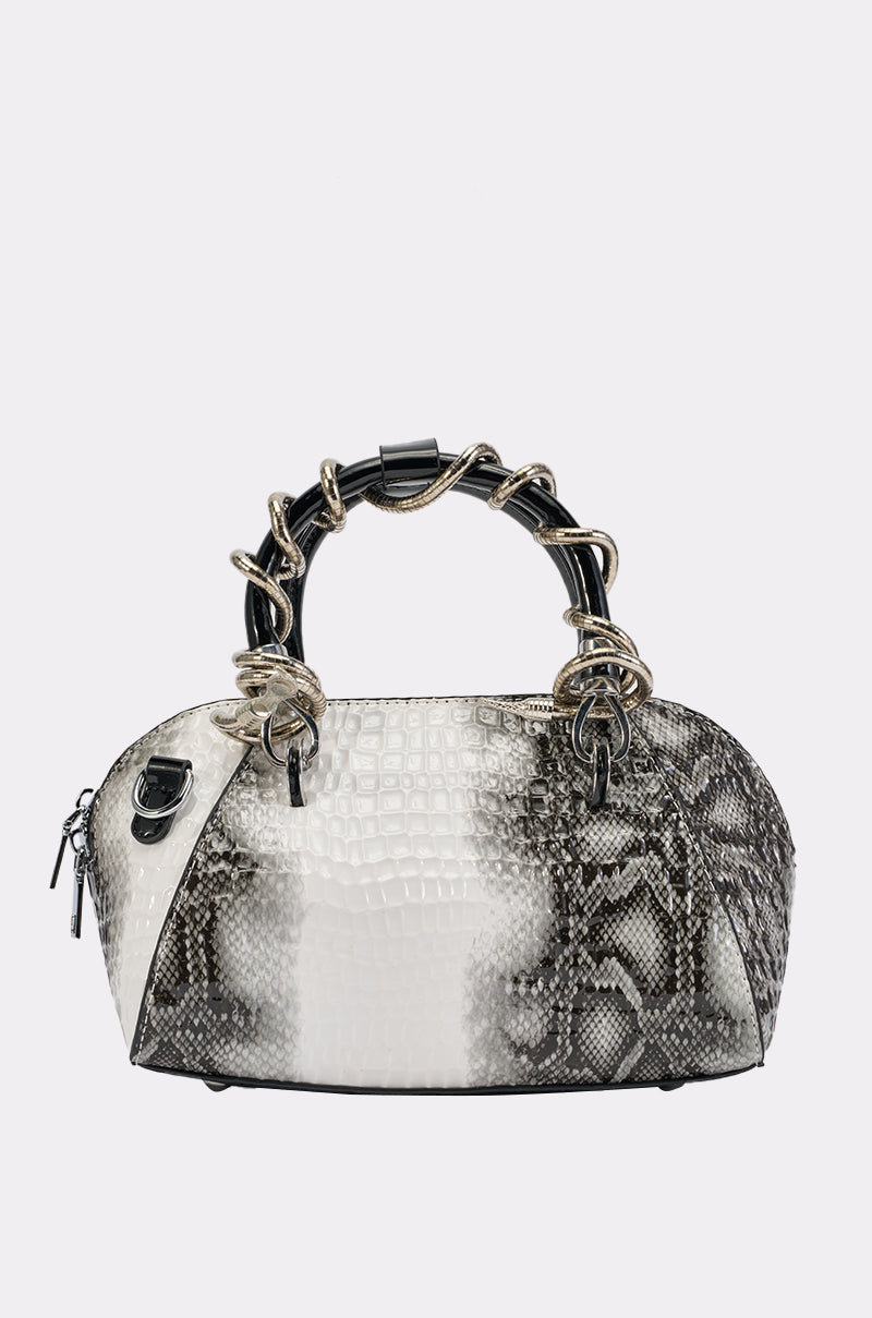 The COME AND GET IT PURSE is a small, dome-shaped handbag in black and white, showcasing a bold snakeskin pattern and a chunky black-and-gold twisted handle. Crafted from stylish faux leather, this accessory stands out against a plain white background and adds modern yet timeless flair to any outfit.