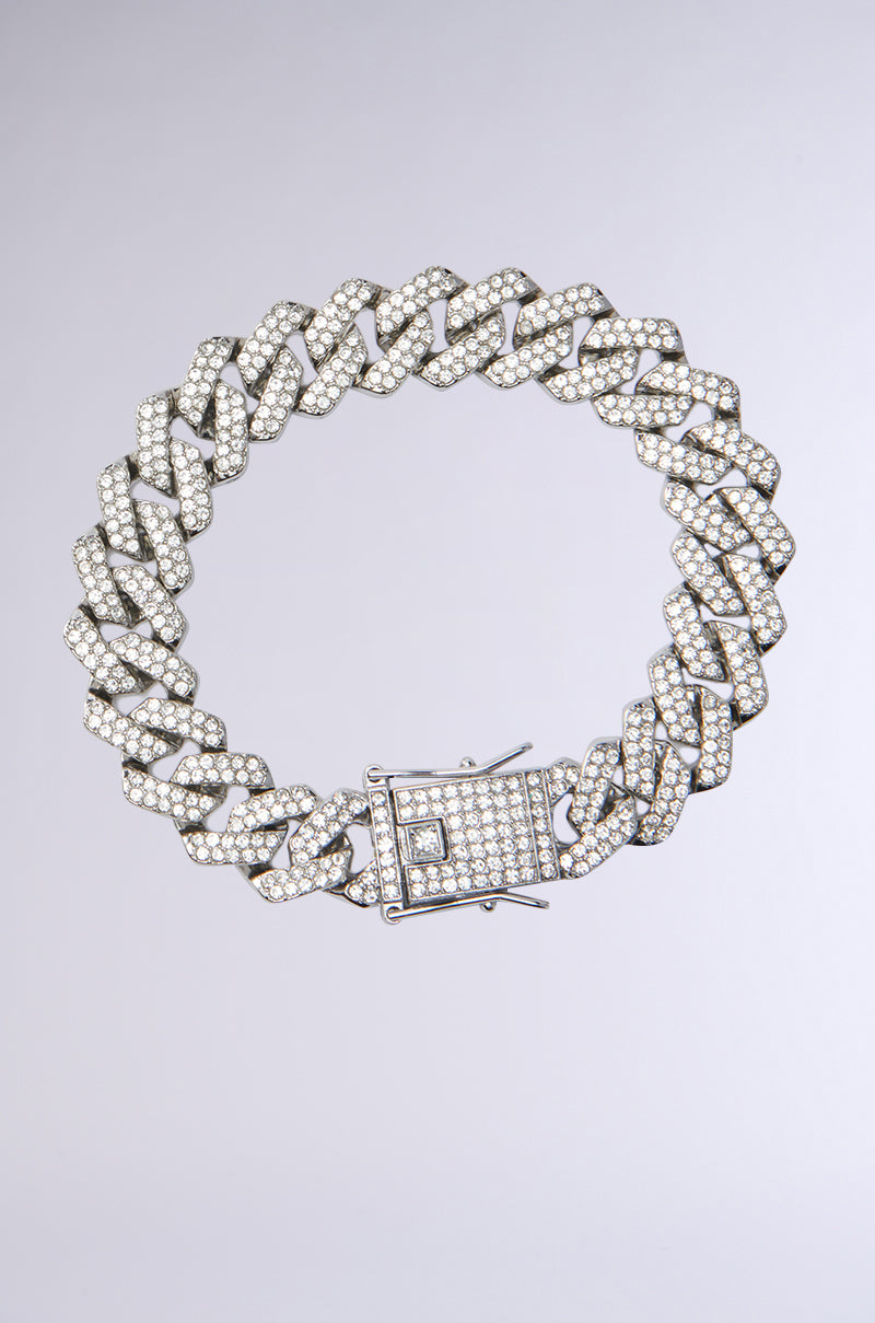 A close-up of the ICE ME OUT BRACELET, a thick Cuban link chain covered in rhinestones, displayed in a circle on a plain light gray background. 0