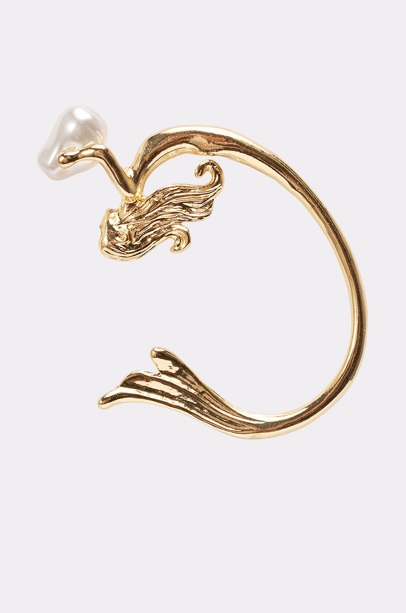 The SIREN EAR CUFF is a gold-tone ear accessory shaped like a wave, featuring a sculpted mermaid holding a faux pearl at one end, shown against a plain white background. 1