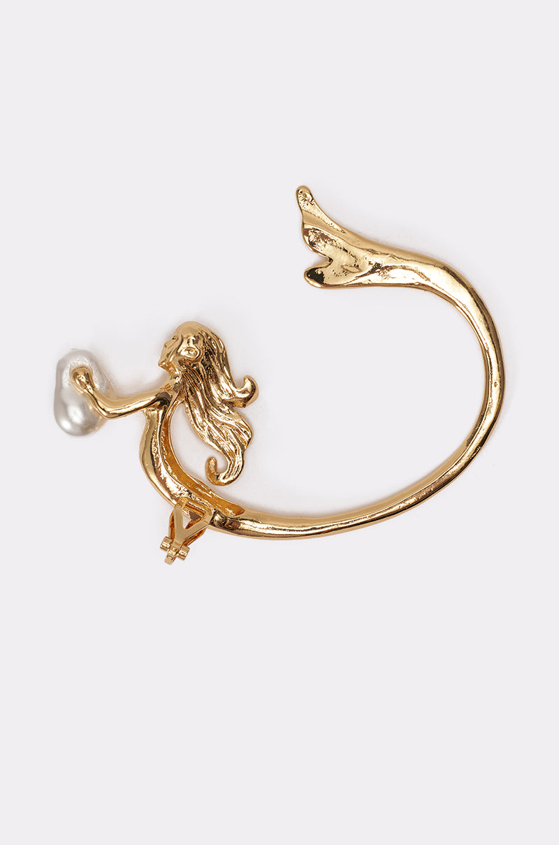 The SIREN EAR CUFF is a gold-tone ear cuff featuring a mermaid holding a small pearl, with her long tail curving elegantly to form an open circle. 3