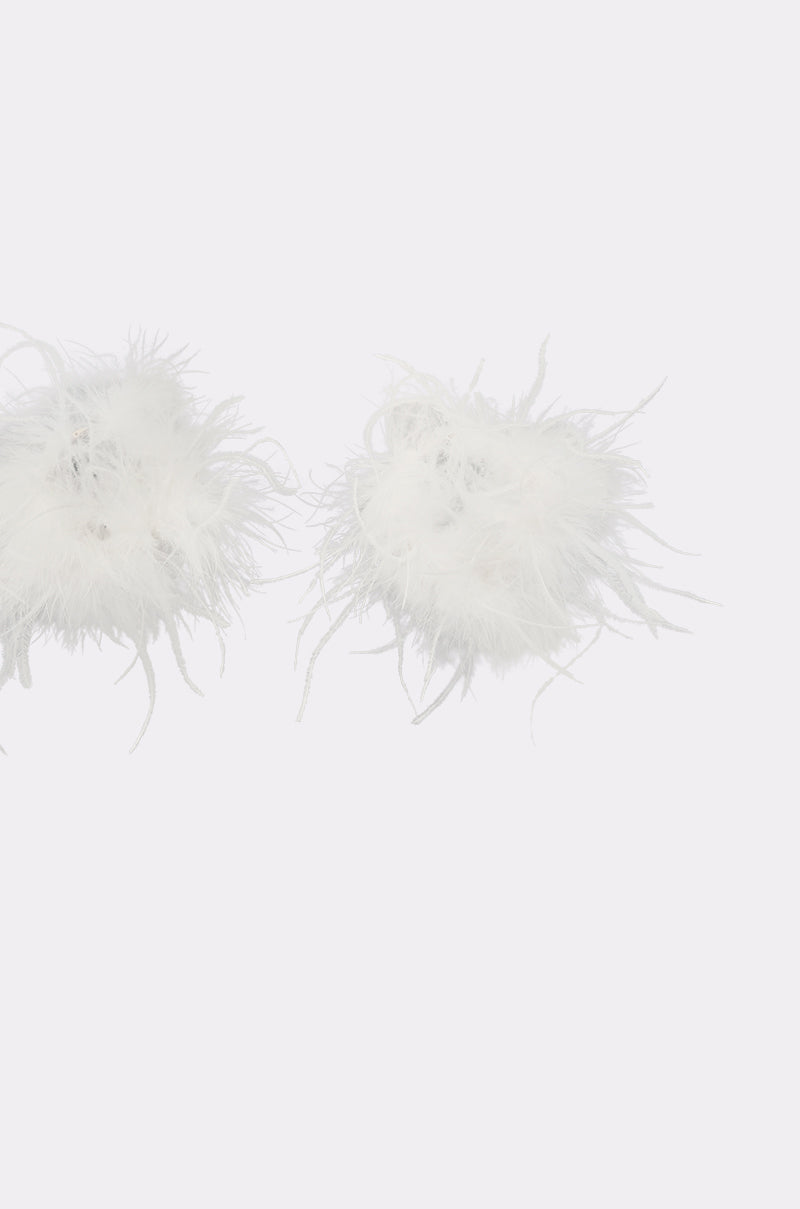 The WITH IT FEATHER HOOP EARRING features two fluffy white feather pom-poms styled as oversized hoops, showcased against a plain light gray background. 3