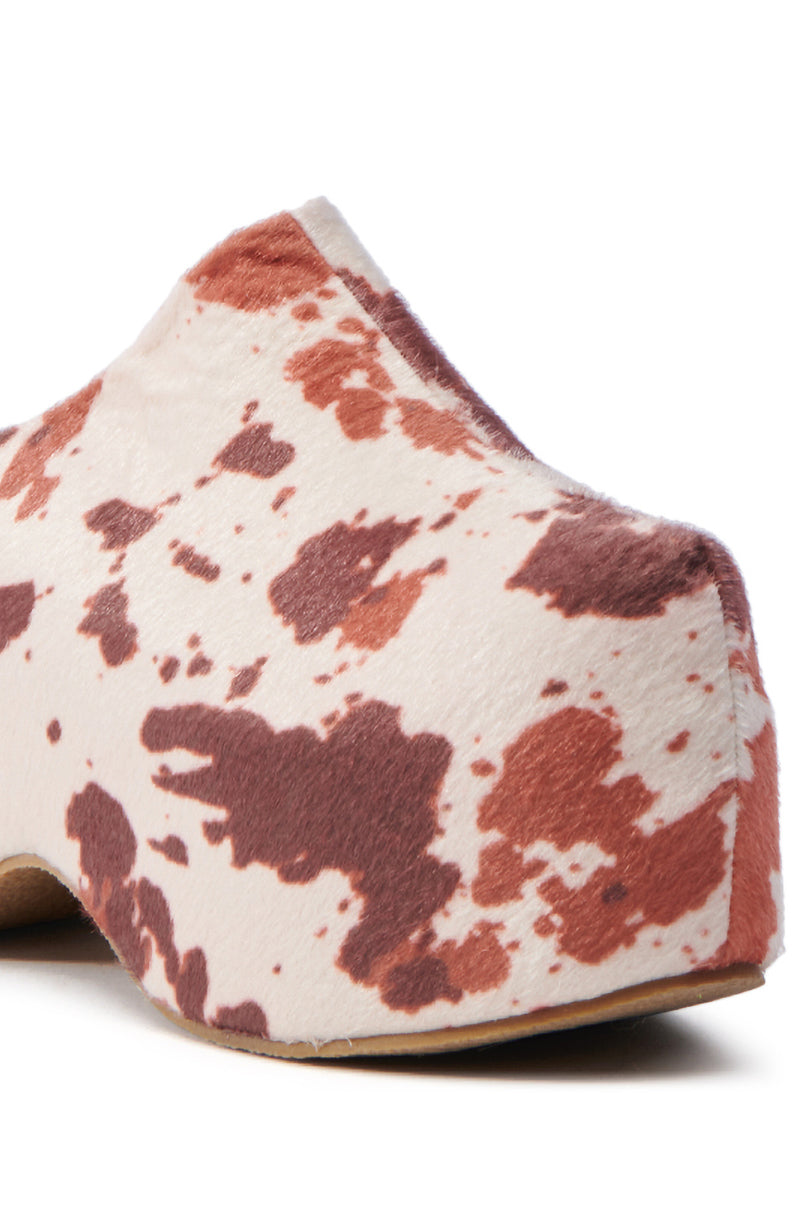 The AZALEA WANG TEATREE COW CLOG features a brown and white cow print pattern with a sleek, lace-free design. Its smooth, rounded shape adds boldness, while the Comfort Cushion Insole offers all-day comfort.
