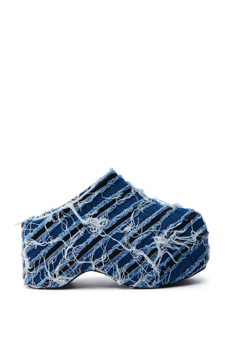 The AZALEA WANG TEATREE DENIM CLOG features a side view of a unique platform shoe in distressed blue denim with frayed edges and a chunky heel, showcasing a layered texture against a plain white background.