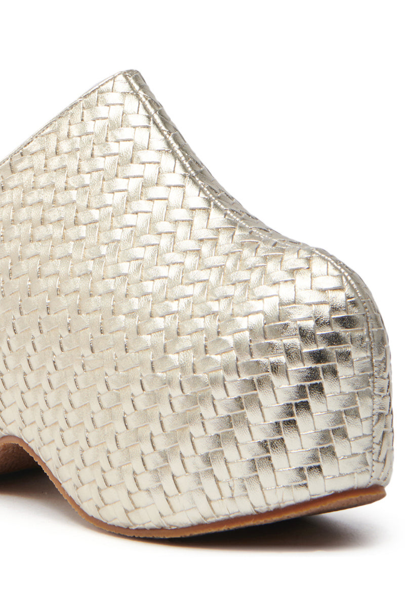 The AZALEA WANG TEATREE GOLD WOVEN CLOG showcases a close-up of its textured metallic vegan leather in a unique woven pattern and features a distinctive curved design with a wooden sole, highlighting exceptional craftsmanship.