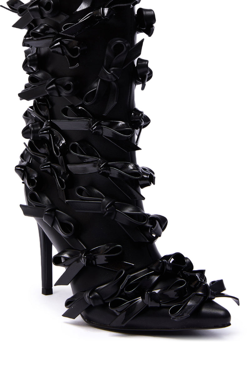 The AZALEA WANG TELMO BLACK BOW EMBELLISHED BOOTIE features a black stiletto heel and is covered from pointed toe to top with shiny black ribbon bows, making a bold and elegant fashion statement.