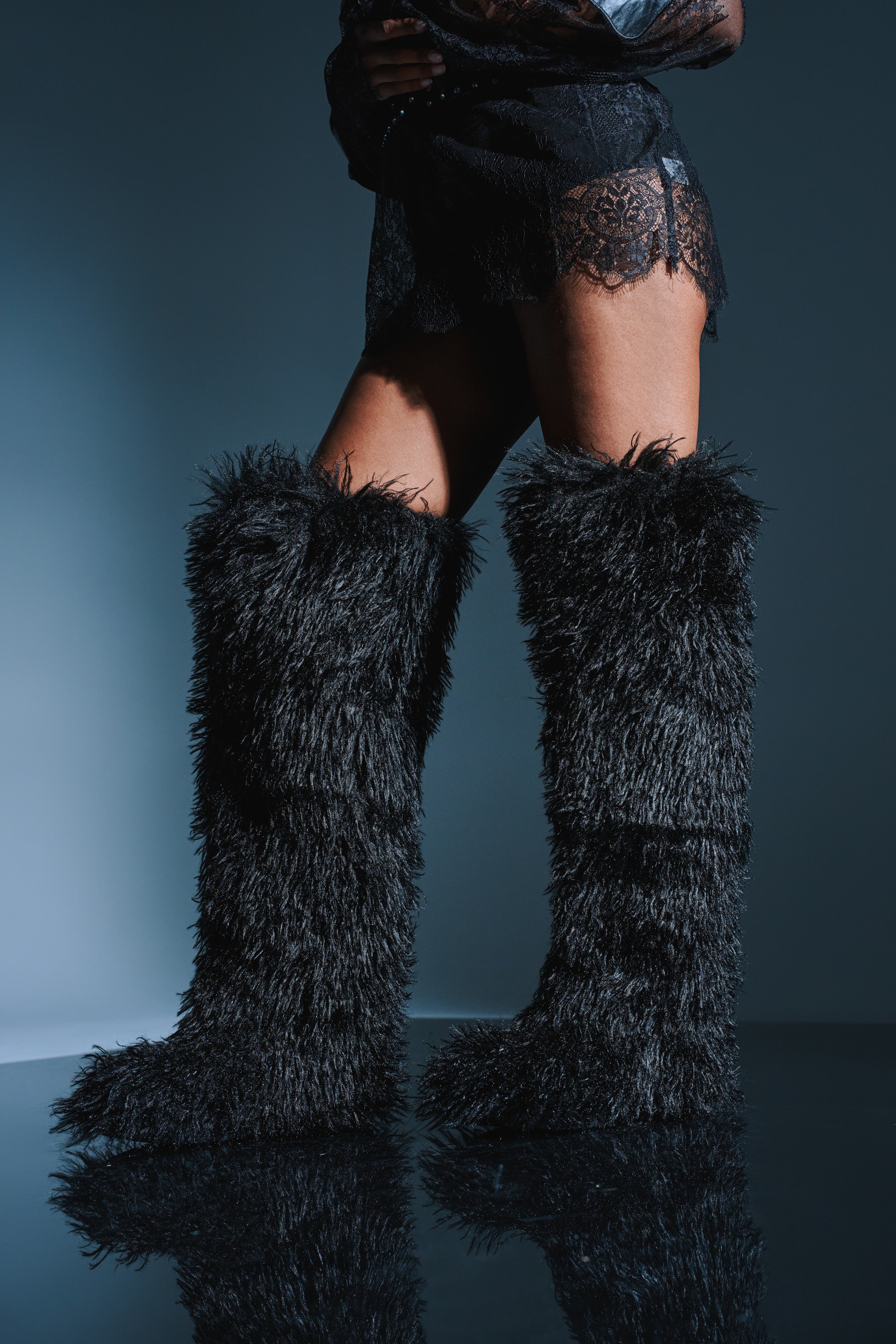 Someone wearing the AZALEA WANG TEMPLETON Black Poodle Faux Fur Over The Knee Boot.
