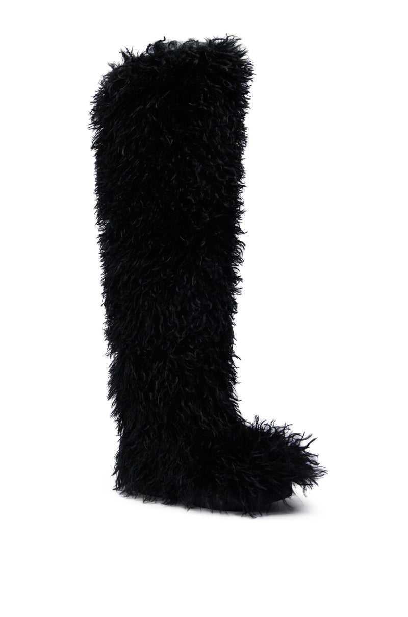 The AZALEA WANG TEMPLETON BLACK POODLE FUR OVER THE KNEE BOOT, featuring a luxurious fluffy, fur-like material for both style and warmth, is showcased as a single tall piece against a white backdrop.