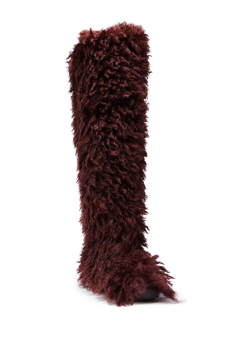 The AZALEA WANG TEMPLETON Burgundy Poodle Fur Over The Knee Boot, covered in shaggy, curly faux fur, stands upright on a white background.