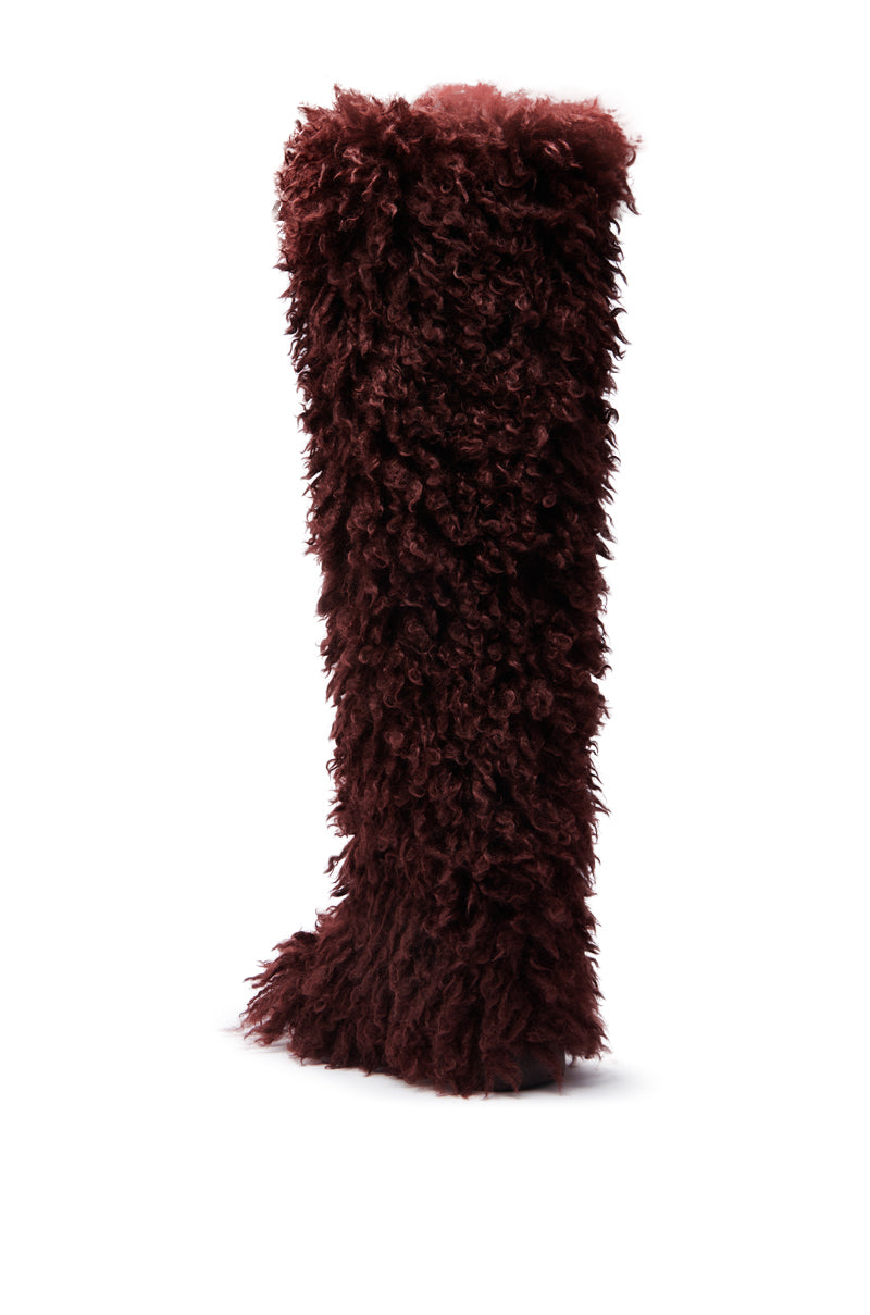 The AZALEA WANG TEMPLETON Burgundy Poodle Fur Over The Knee Boot features thick, curly burgundy poodle fur and a slightly irregular shape, shown against a white background.