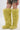 A person wears the AZALEA WANG TEMPLETON LIME POODLE FUR OVER THE KNEE BOOT with a short, ruffled leopard print skirt, standing against a plain white background.