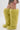 A person wears tall, fuzzy, light yellow AZALEA WANG TEMPLETON LIME POODLE FUR OVER THE KNEE BOOTS with a short leopard print skirt against a plain white background.