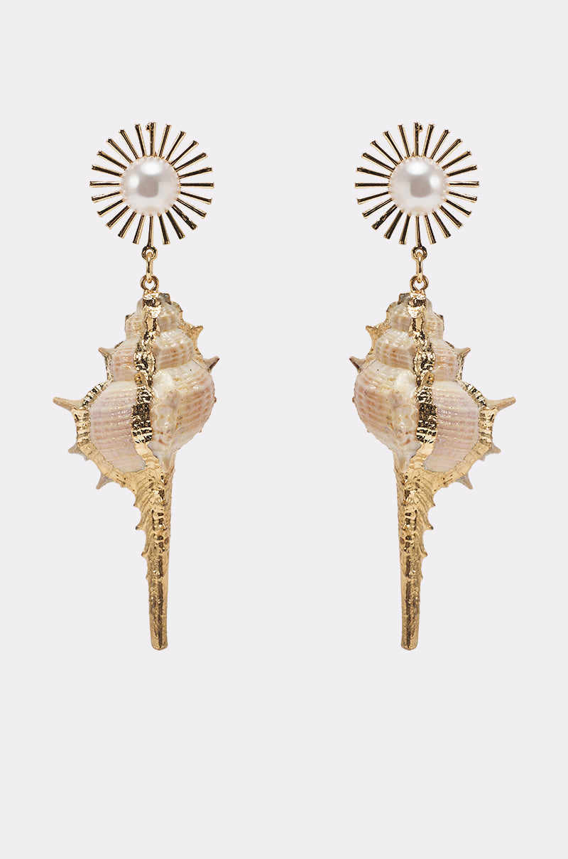 TO THE SHORE EARRING: Gold pearl earrings with sunburst studs, pearl centers, and dangling gold-toned seashell charms—an elegant beach jewelry piece displayed on a simple light background. 1