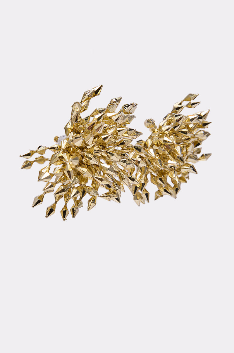 The EDGY VIBE EARRING features an abstract gold metallic design with numerous pointed, faceted spikes clustered together, creating an intricate and dynamic structure that resembles an oversized earring against a plain white background. 2