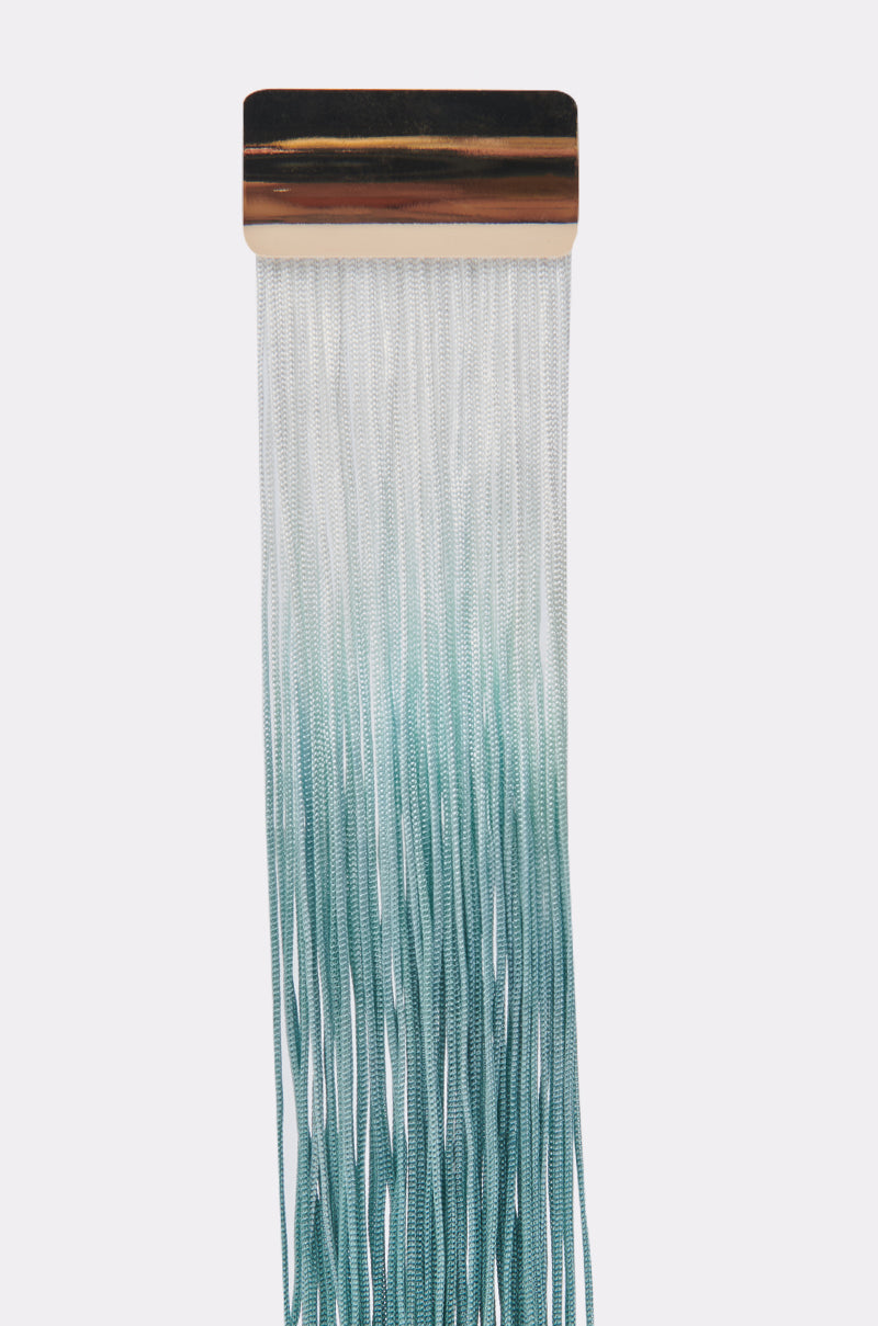 The REBRAND EARRING features a rectangular metallic design with long, thin strands resembling tassel fringe, blending from white at the top to teal at the bottom, displayed against a light background. 4