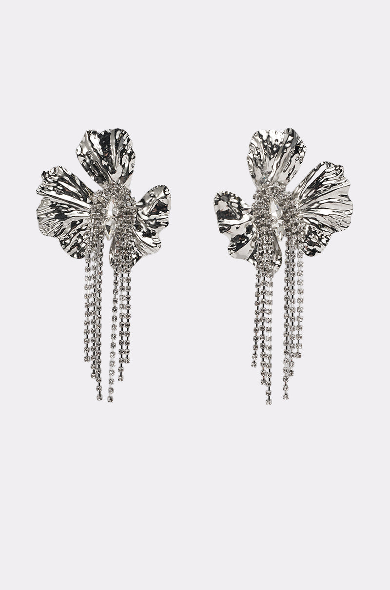 The ON A TRIP EARRING features silver-tone drop earrings shaped like abstract flowers with textured petals and cascading strands of dangling chains, set against a plain white background. 1