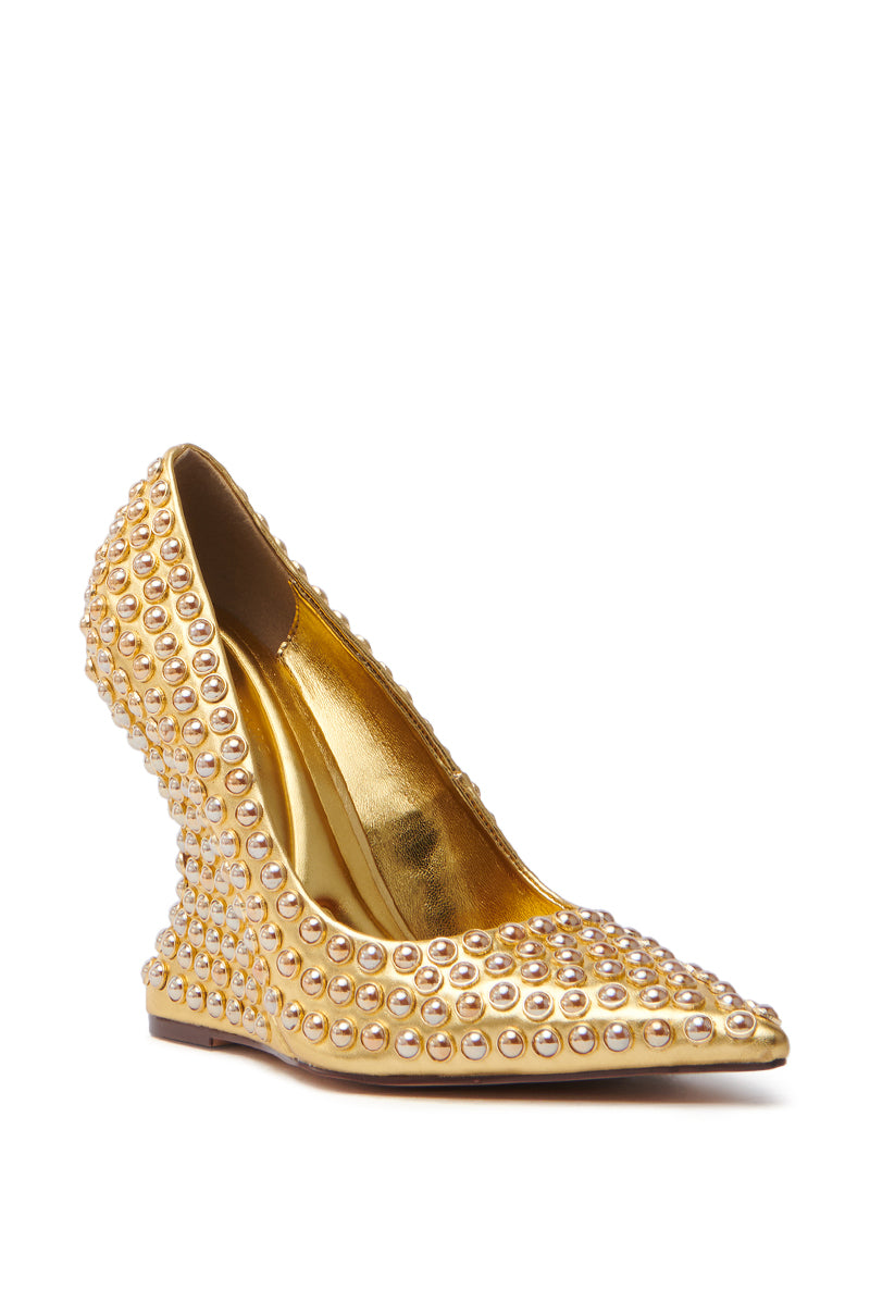 The AZALEA WANG TERYN GOLD WEDGE PUMP is a luxurious shoe with a pointed toe and intricate stud design, crafted from metallic vegan leather. Encrusted with pearls, its shimmering metallic gold sole and interior enhance its elegant appearance.