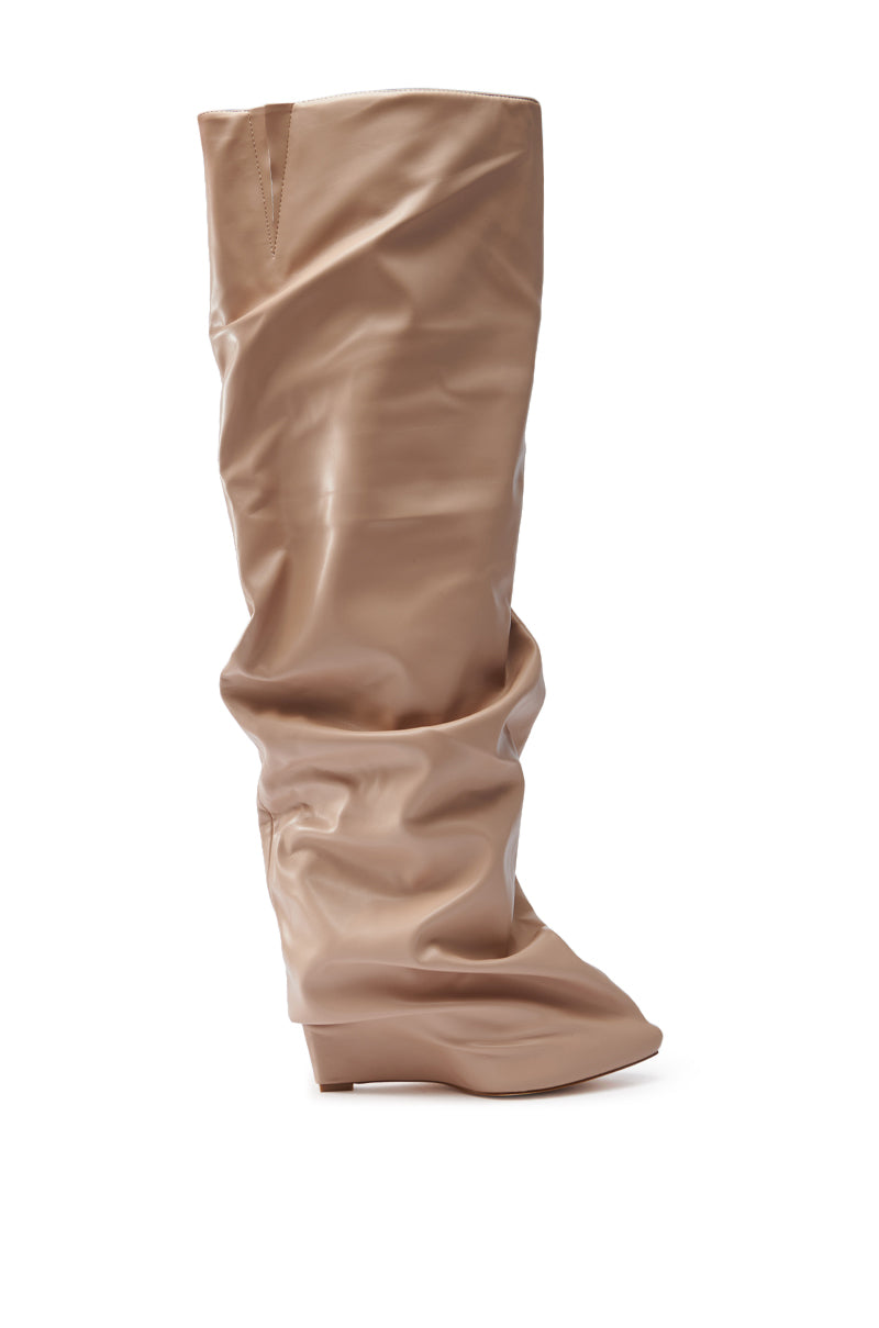A single AZALEA WANG TEUILA BONE WEDGE RUCHED BOOT is displayed. Made from vegan leather, it features a relaxed, wrinkled look with a glossy finish, and extends to knee height. The background is plain white.
