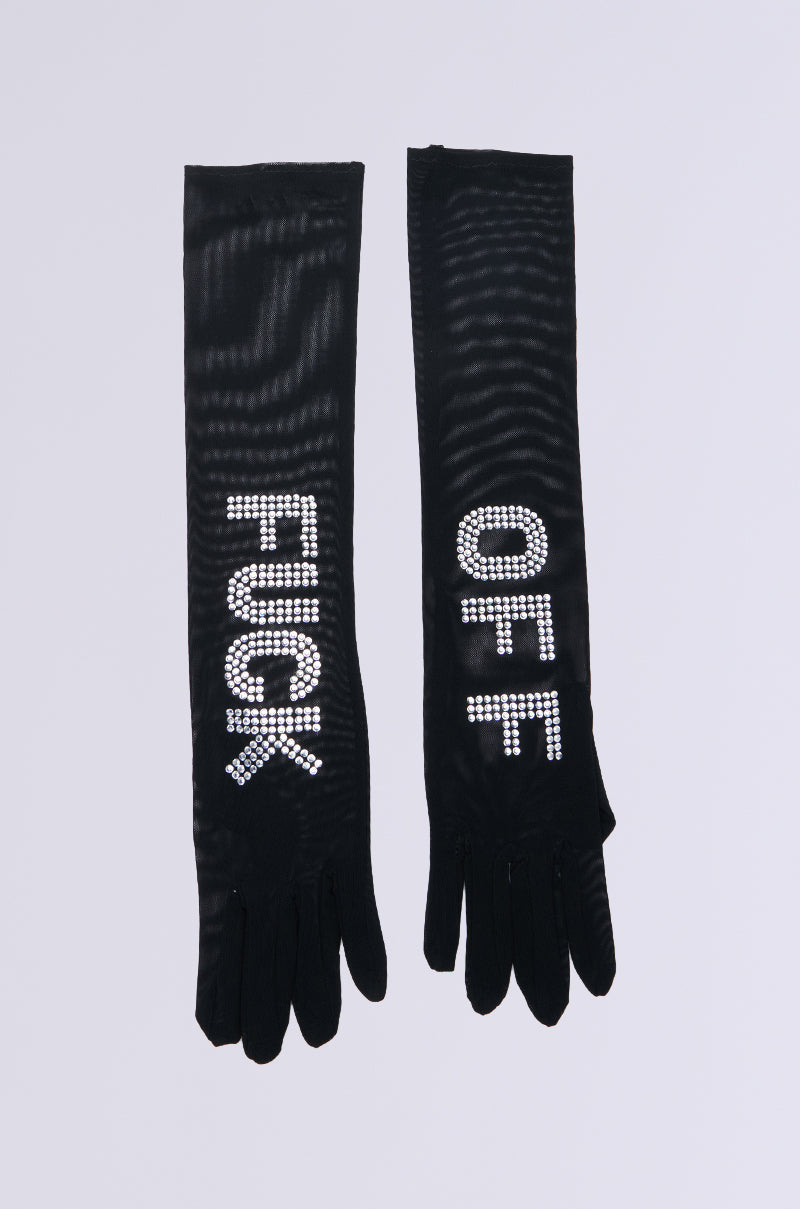 The YOU GET THE MESSAGE MESH GLOVES are opera-inspired black mesh gloves adorned with rhinestones that spell "FUCK" and "OFF" on each hand, set against a simple gray backdrop, adding dramatic flair to these striking accessories. 2