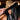 A woman with long dark hair in a black sleeveless top partially covers her face with the CHECK ME OUT FAUX FUR COWBOY HAT, a bold leopard print western accessory, styled with layered silver cross necklaces for added edge.