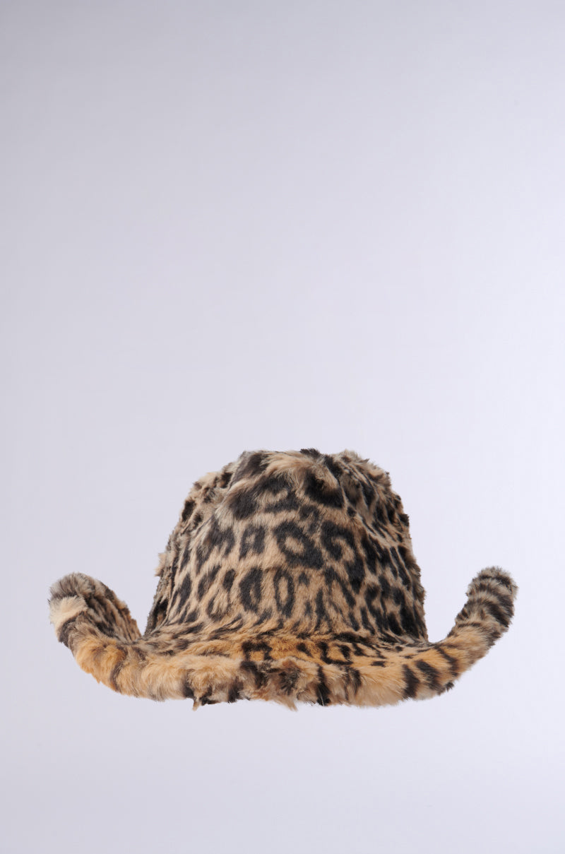 The CHECK ME OUT FAUX FUR COWBOY HAT, featuring a leopard print design and a wide, curving brim on a light gray background, adds a bold Western accessory to any outfit.