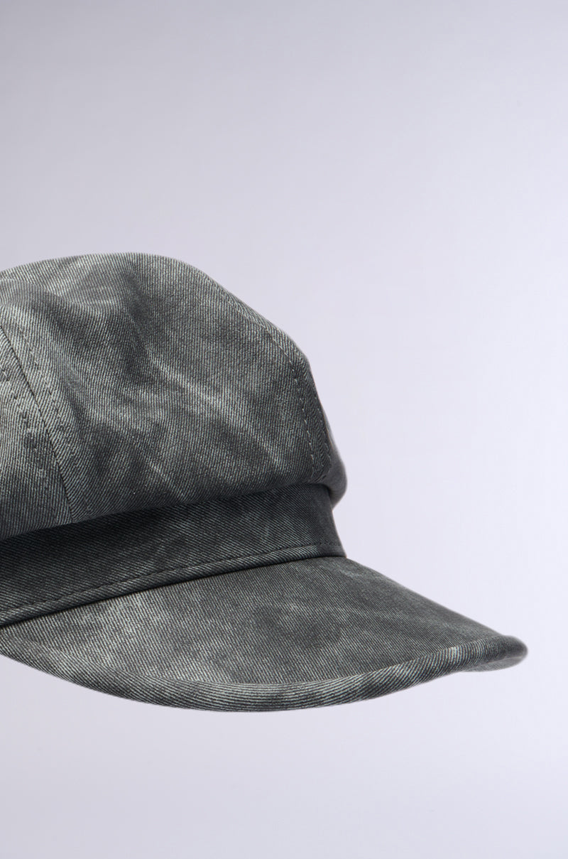 A close-up of the IT GURL PU BRIM HAT shows its gray denim fabric and faux leather brim, with detailed stitching and subtle AKIRA Label flair, set against a light gray background and angled to highlight its textured look. 6