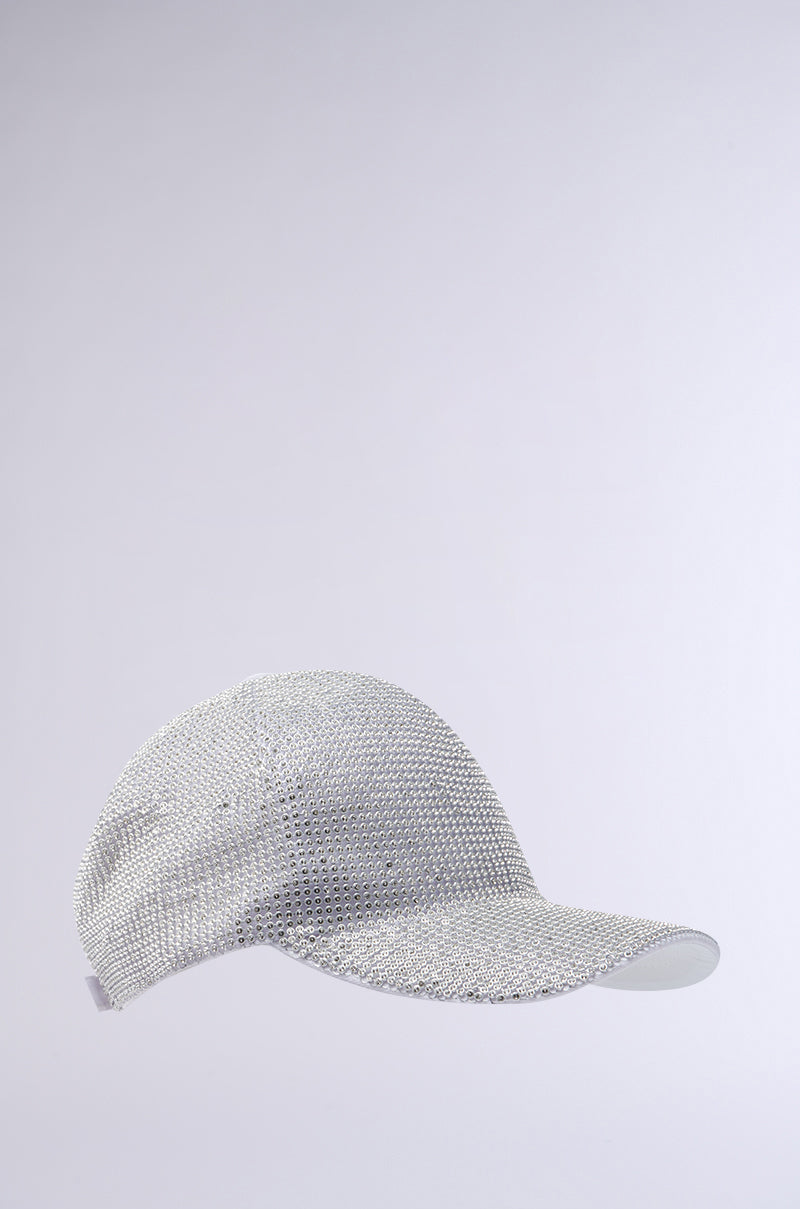 The IM RICH BLING SNAPBACK, a silver baseball cap with a sparkling rhinestone overlay and adjustable back strap, is shown against a plain light grey background. 3