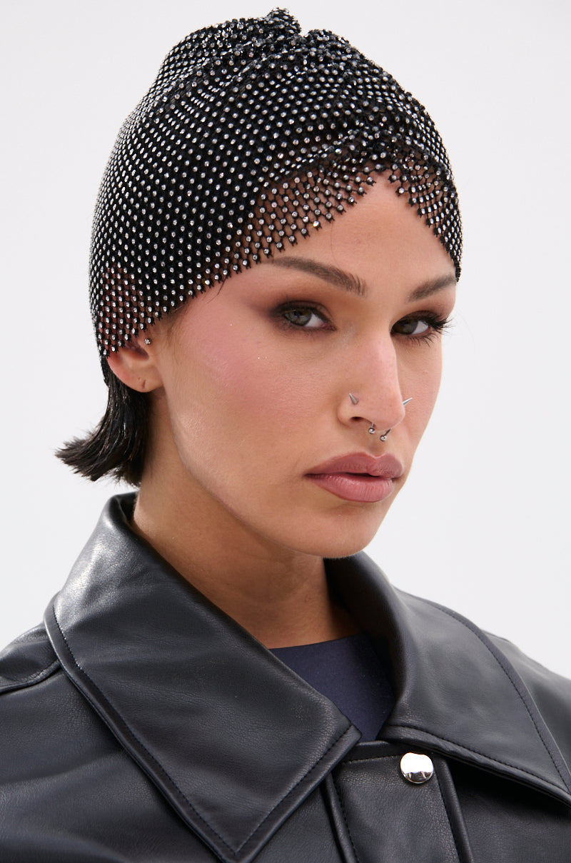 Wearing the ELI BLING HAIR TUBAN, a person with short dark hair, facial piercings, and a black leather jacket looks confidently at the camera against a plain background.