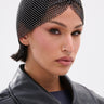 Wearing the ELI BLING HAIR TUBAN, a person with short dark hair, facial piercings, and a black leather jacket looks confidently at the camera against a plain background.