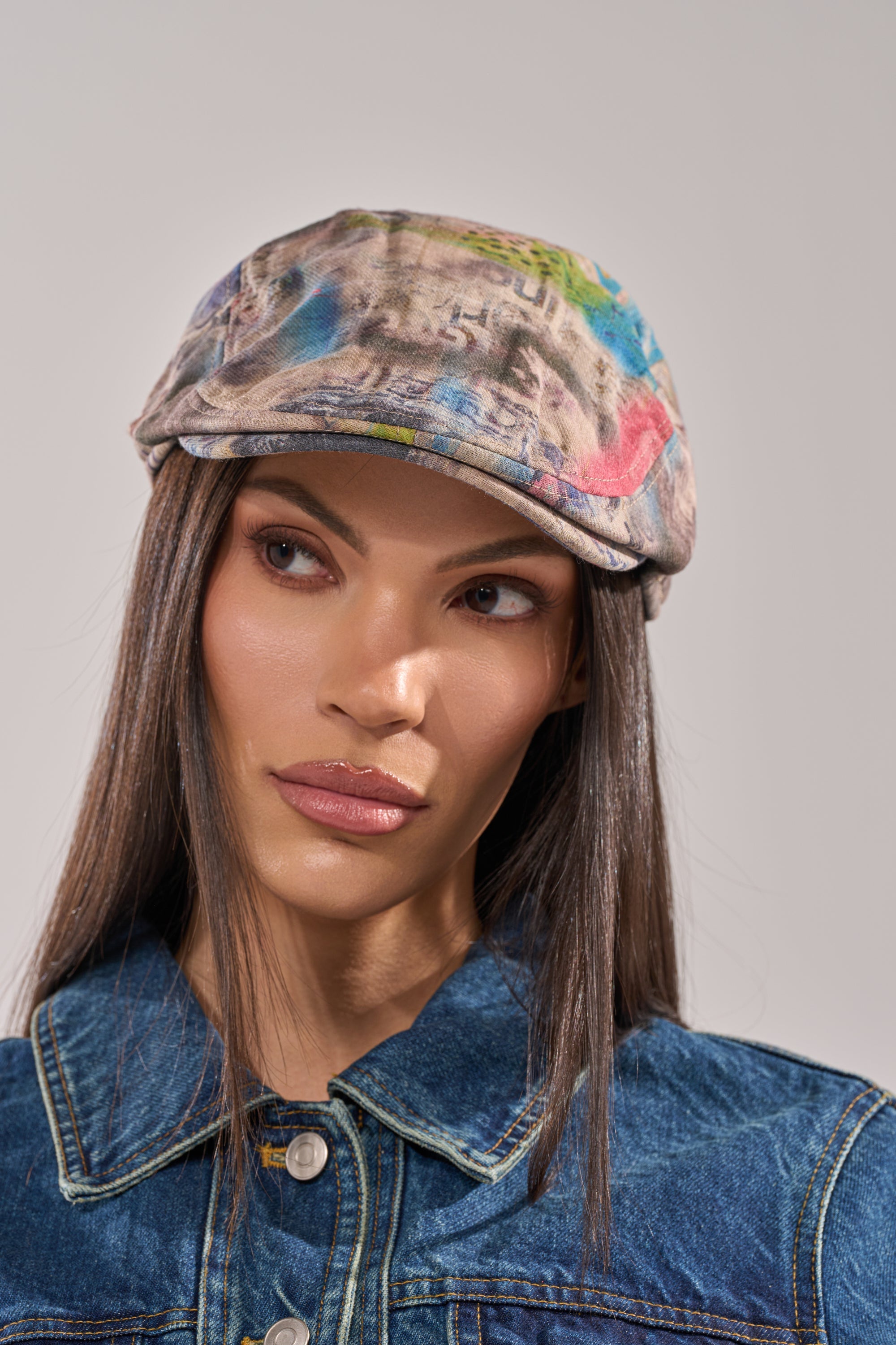 A person with long straight hair wears the IM OUTSIDE GRAFFITI HAT and a denim jacket, looking slightly to the side with a neutral expression against a plain background. 1