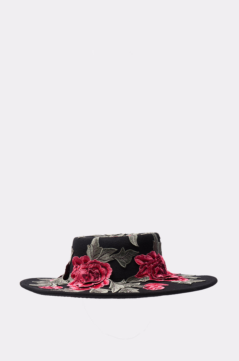 The ALIYA FLORAL BRIM HAT is a wide-brimmed black hat embroidered with pink and red flowers plus green leaves around the brim and crown, displayed on a plain light background. 1