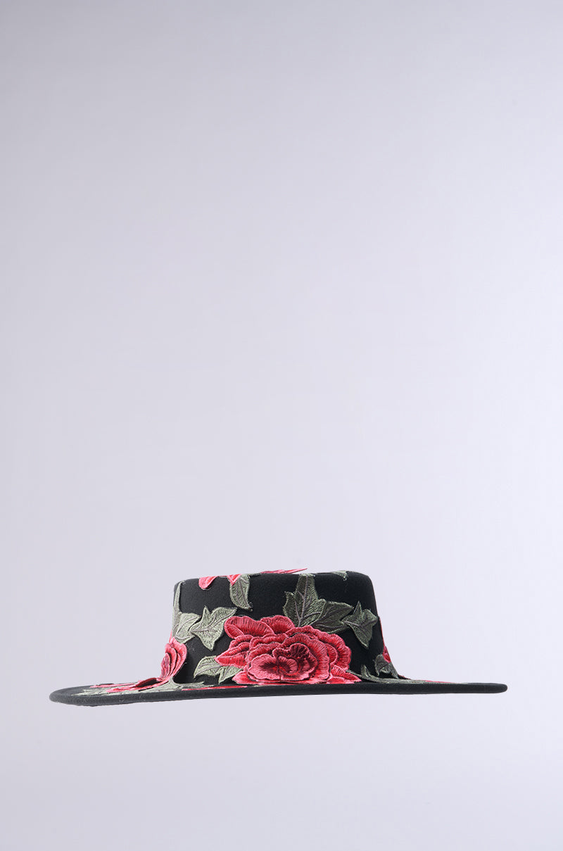 Introducing the ALIYA Floral Brim Hat: a stunning wide-brimmed, black hat embellished with embroidered red roses and green leaves on a simple light gray background. 7