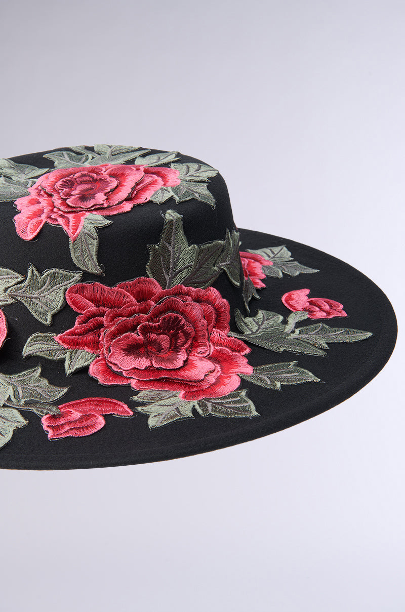 The ALIYA FLORAL BRIM HAT from AKIRA Label showcases large red and pink embroidered roses with lush green leaves on a delicate light gray background, offering exquisite floral appliqués that adorn the top and brim, making it a standout accessory. 8