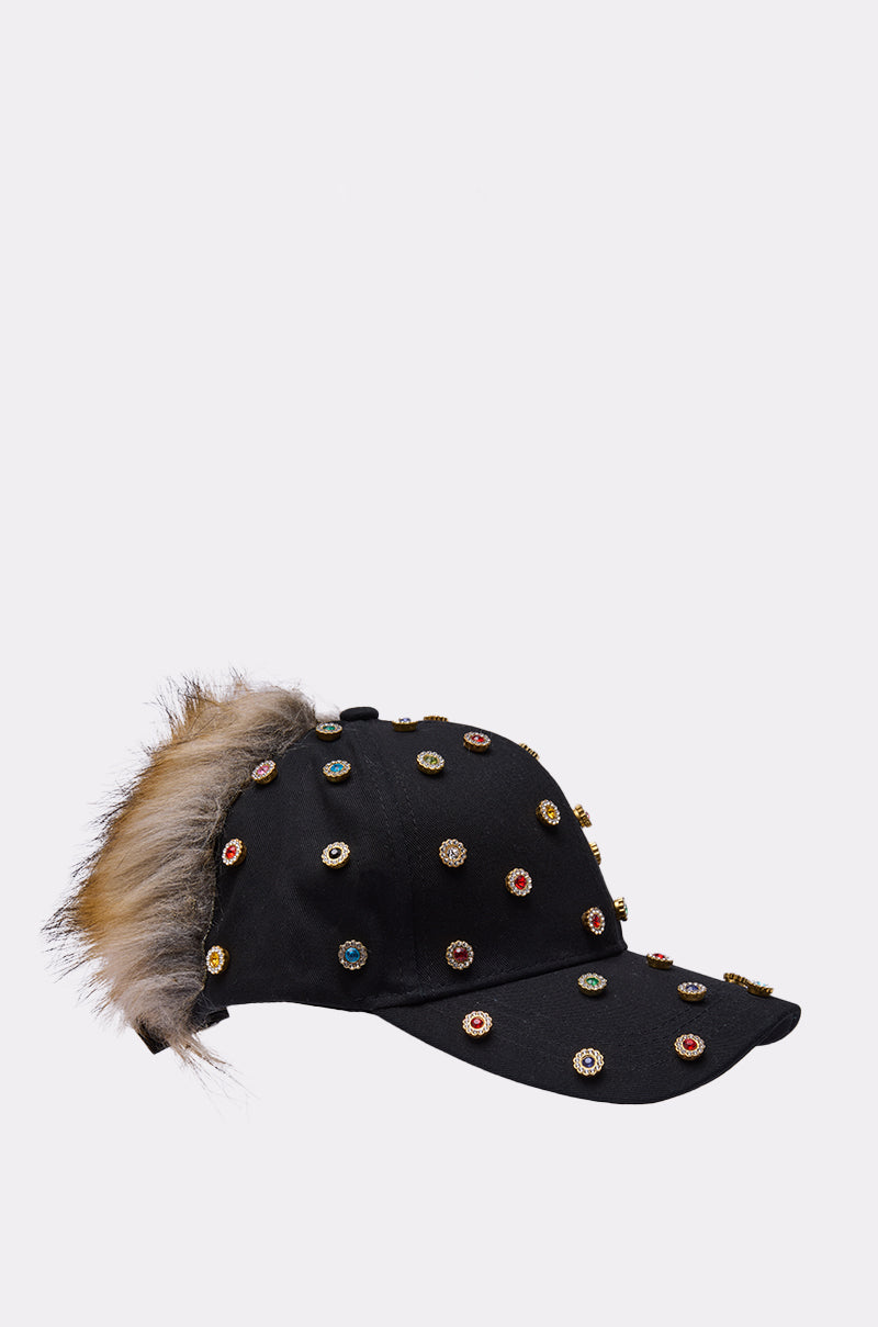 The TJ FAUX FUR EMBELLISHED HAT is a black AKIRA Label baseball cap adorned with colorful jeweled studs and brown and gray faux fur at the back, shown on a plain white background. 5