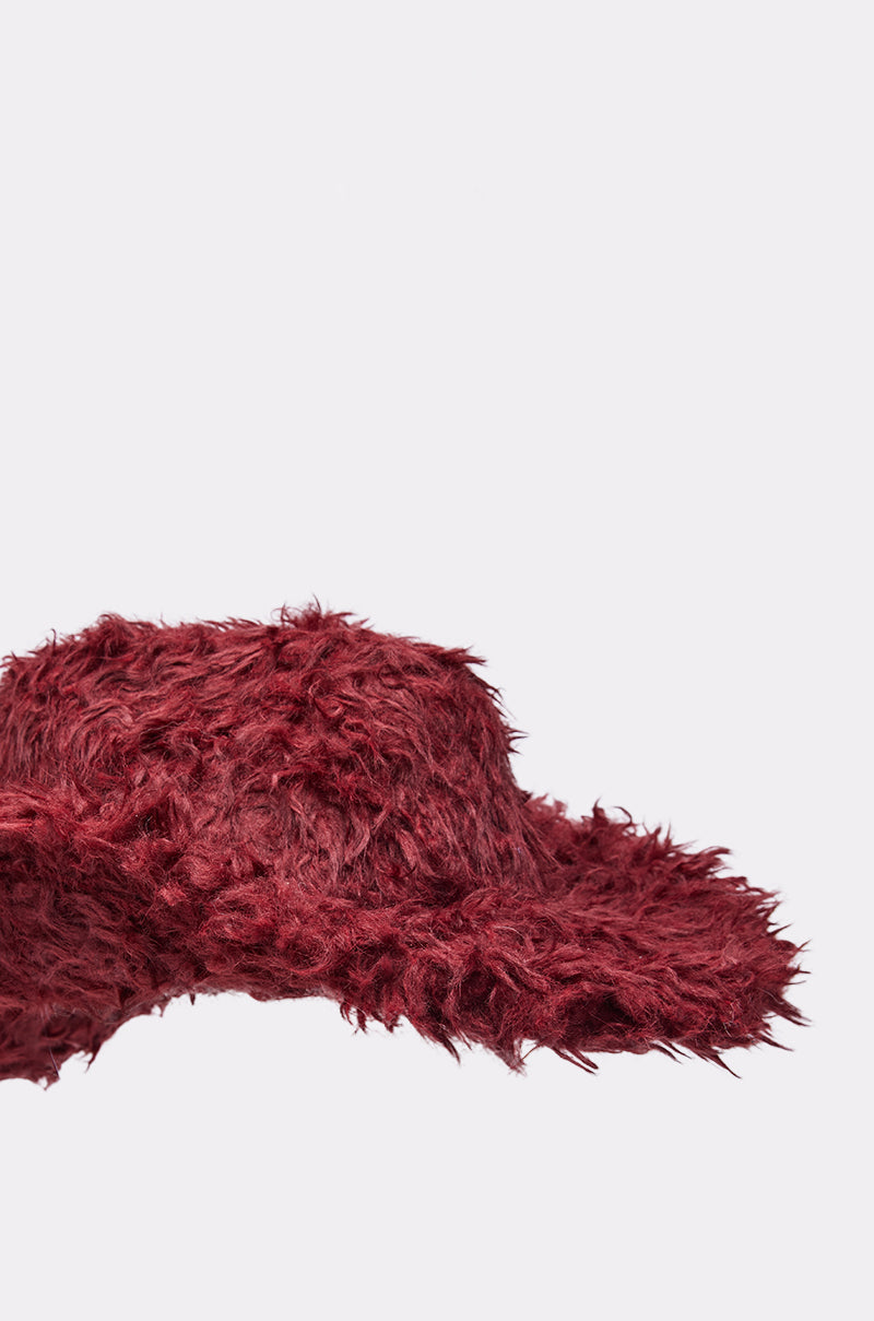 The FOR THE VIBES FAUX FUR COWBOY HAT features a wide-brimmed, fuzzy maroon design with a soft, shaggy texture, shown against a plain light background—perfect for adding Western flair to your festival accessory collection. 5