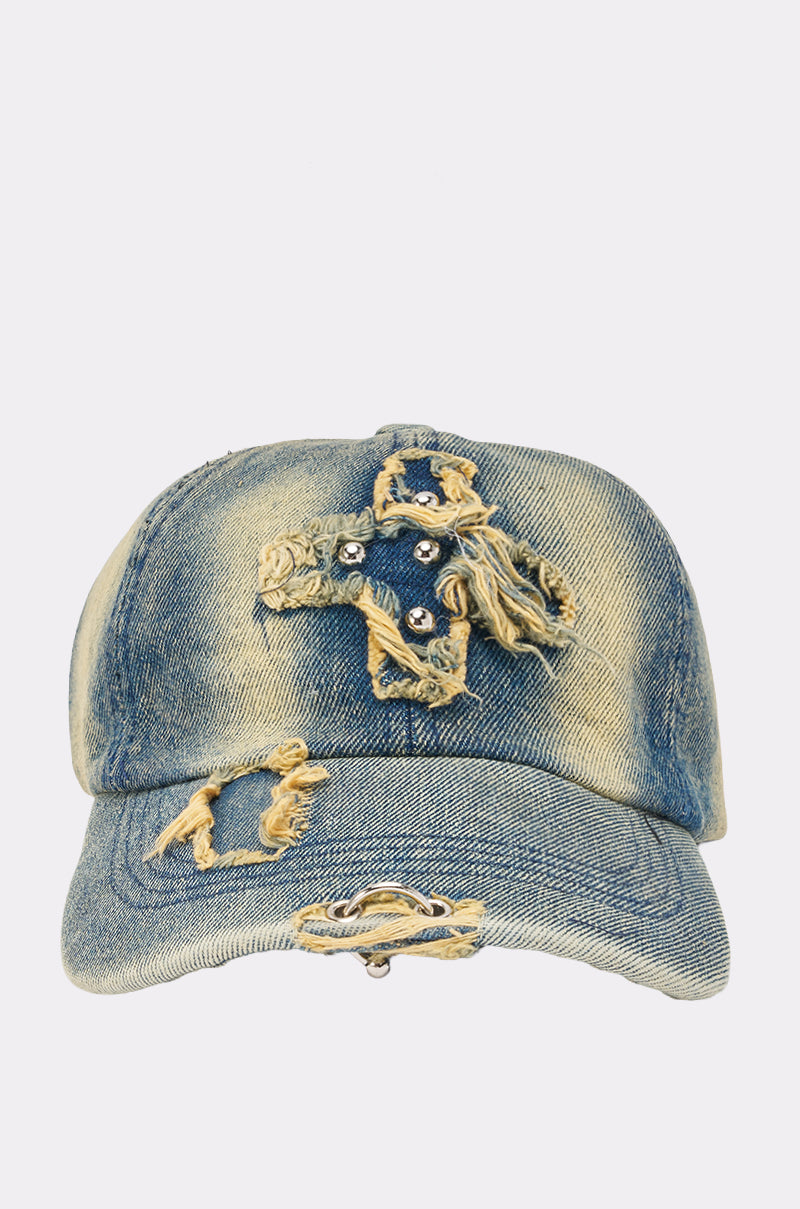The POST ME HAT is a distressed denim baseball cap with frayed patches and holes on the front and brim, offering a rugged, worn-out look that's perfect for festival styling.