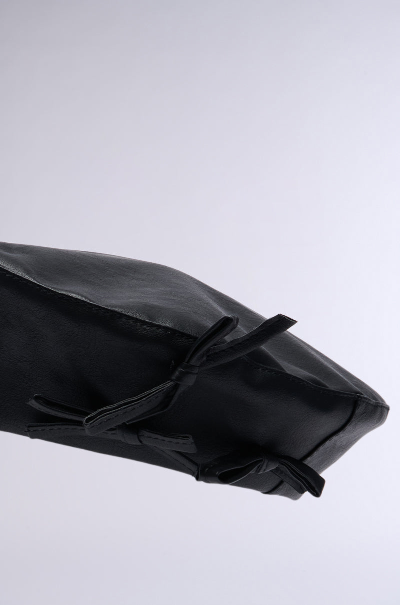 Close-up of a black PRETTY IN PU BOW BERET with a smooth texture, featuring several tied leather straps on one side. The faux leather beret is set against a plain gray background and boasts adjustable drawstrings for a perfect fit. 5