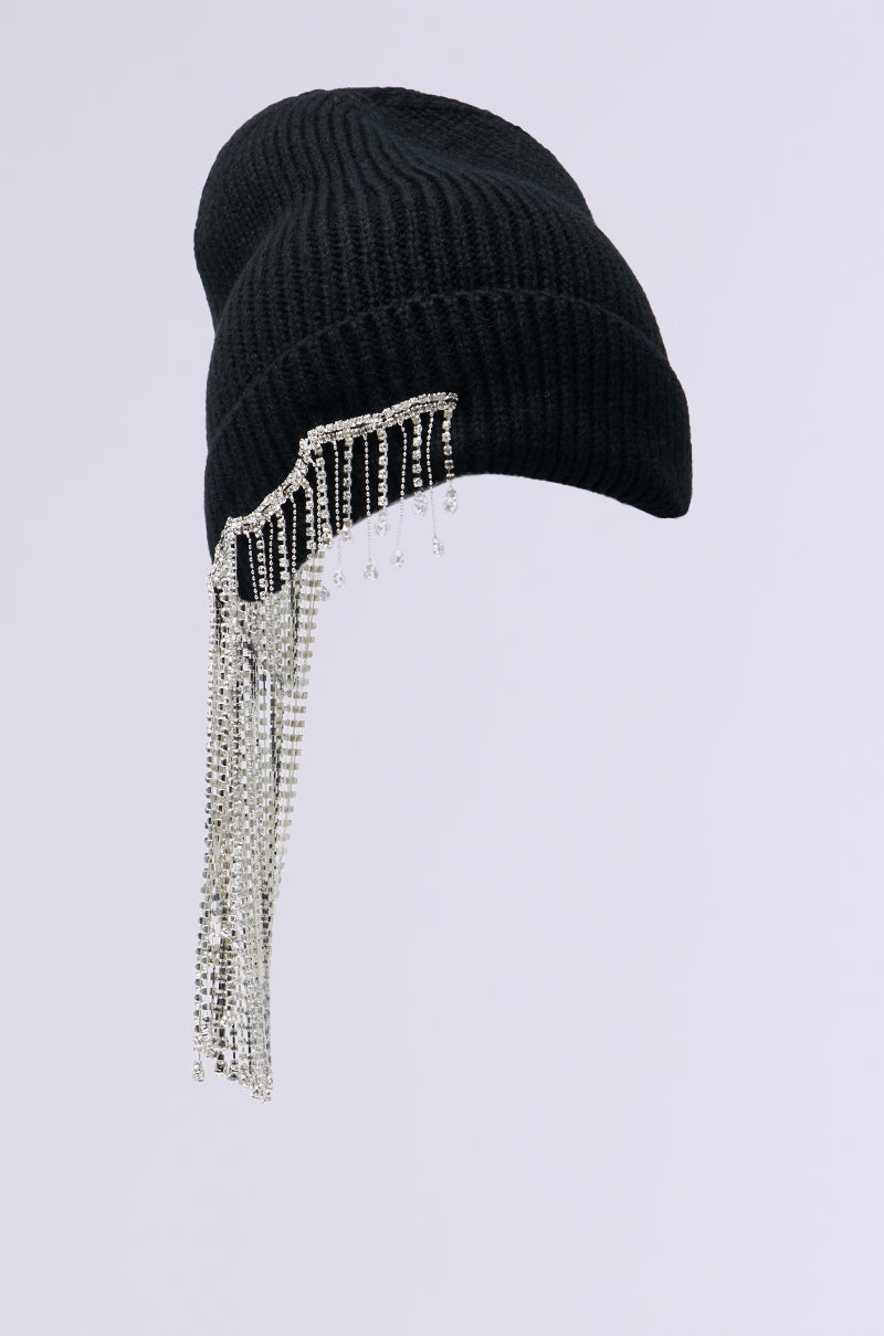 Introducing the RIRI RHINESTONE FRINGE BEANIE: a black knit winter accessory adorned with elegant cascading silver rhinestones on one side, perfect for adding bling to your look.