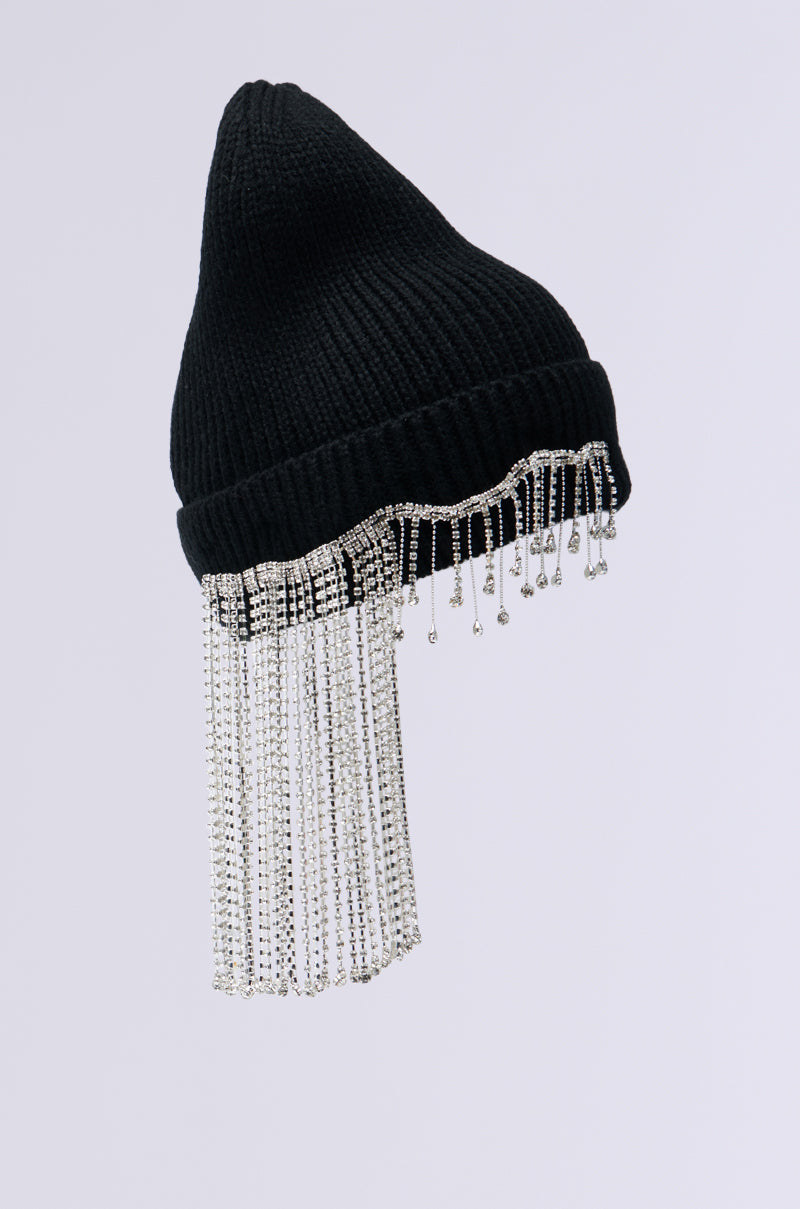 The RIRI RHINESTONE FRINGE BEANIE is a striking winter accessory with a black knit base and silver beaded fringe cascading from the brim, all set against a simple white background to enhance its sparkle.