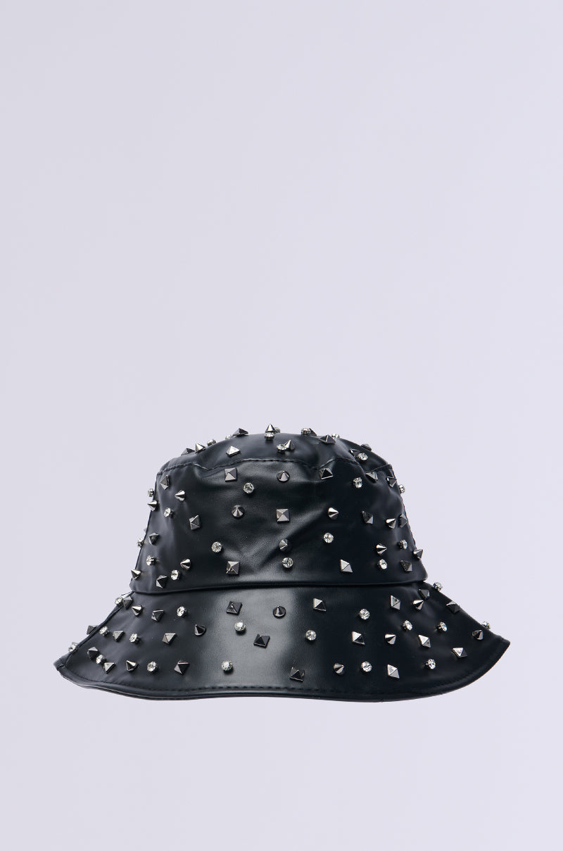 The SUGAR AND SPICE BUCKET HAT is a sleek black faux leather accessory, embellished with metal studs and subtle spikes against a plain light gray background.