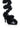 Introducing the AZALEA WANG THEODOSIA BLACK FLORAL STILETTO SANDAL: a stunning black stiletto sandal featuring a spiral of black floral embellishments that elegantly wrap around the ankle. The glossy finish of the faux patent leather beautifully contrasts with the textured flowers, resulting in an elegant and striking appearance.