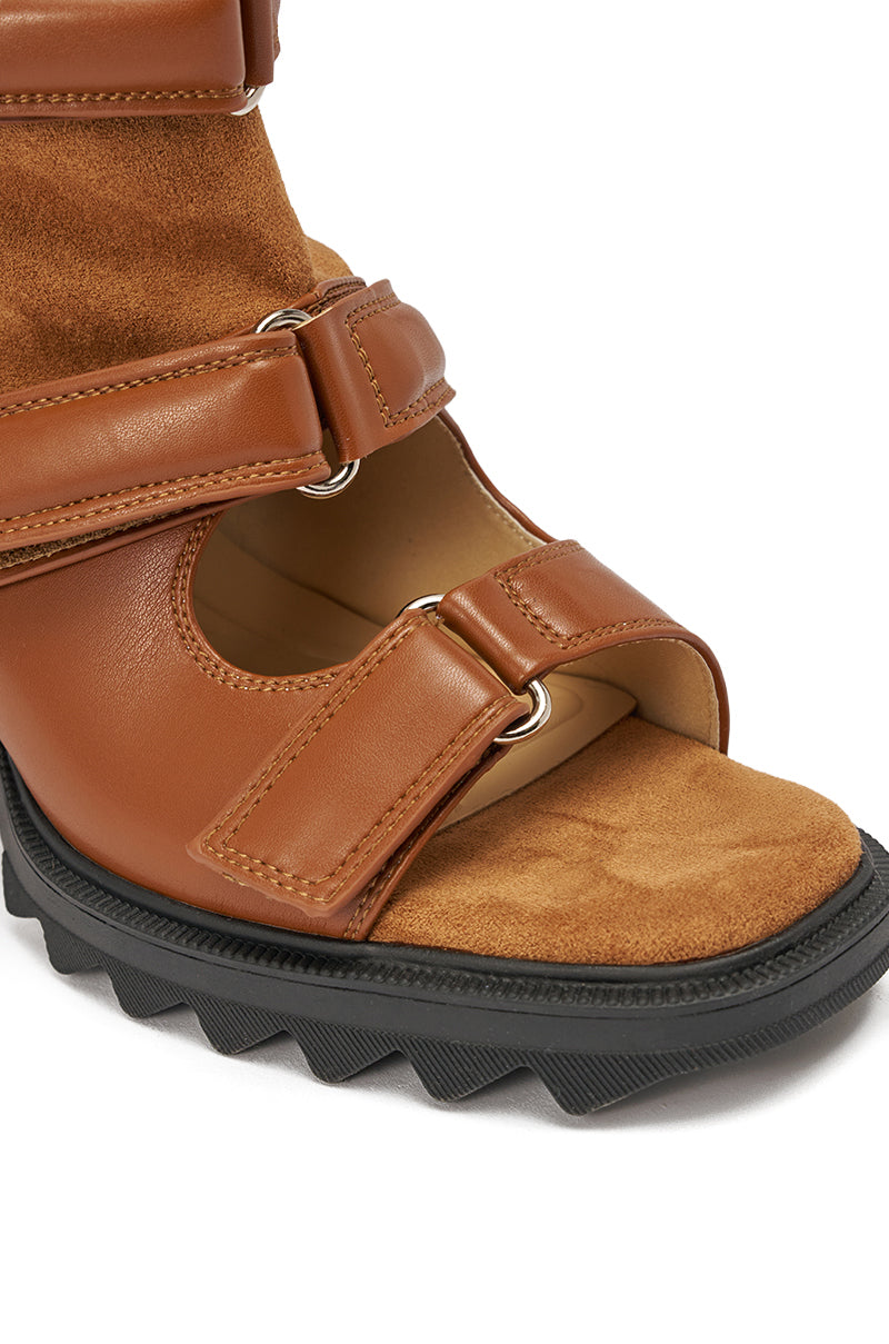 Close-up of the AZALEA WANG THIERRY TAN FAUX SUEDE OPEN TOE CHUNKY BOOTIE, featuring brown faux suede and leather straps, Velcro closures, metal ring accents, exposed toes, and a thick black textured platform-style sole. 5