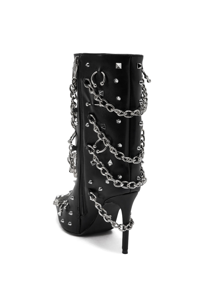 The AZALEA WANG THRIGRUN BLACK SILVER HARDWARE STILETTO BOOTIE, featuring black faux leather and chunky silver hardware chains, is shown from the back against a plain white background.