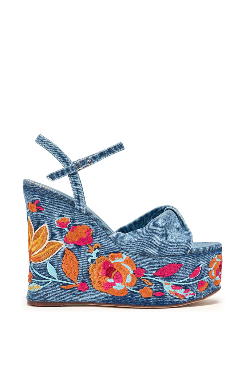 The AZALEA WANG TIALA DENIM FLORAL EMBROIDERED STRAP WEDGE SANDAL features a denim design with an ankle strap and colorful floral embroidery in orange, yellow, red, and blue on the platform heel and shoe’s side. 4