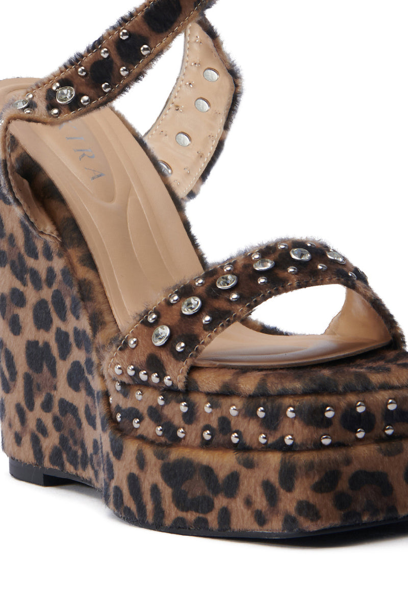 Close-up of the AZALEA WANG TIBIL LEOPARD WEDGE SANDAL with a sleek leopard print and studded details. This chic open-toe shoe boasts a platform sole and thick wedge heel, blending style and comfort for any occasion.