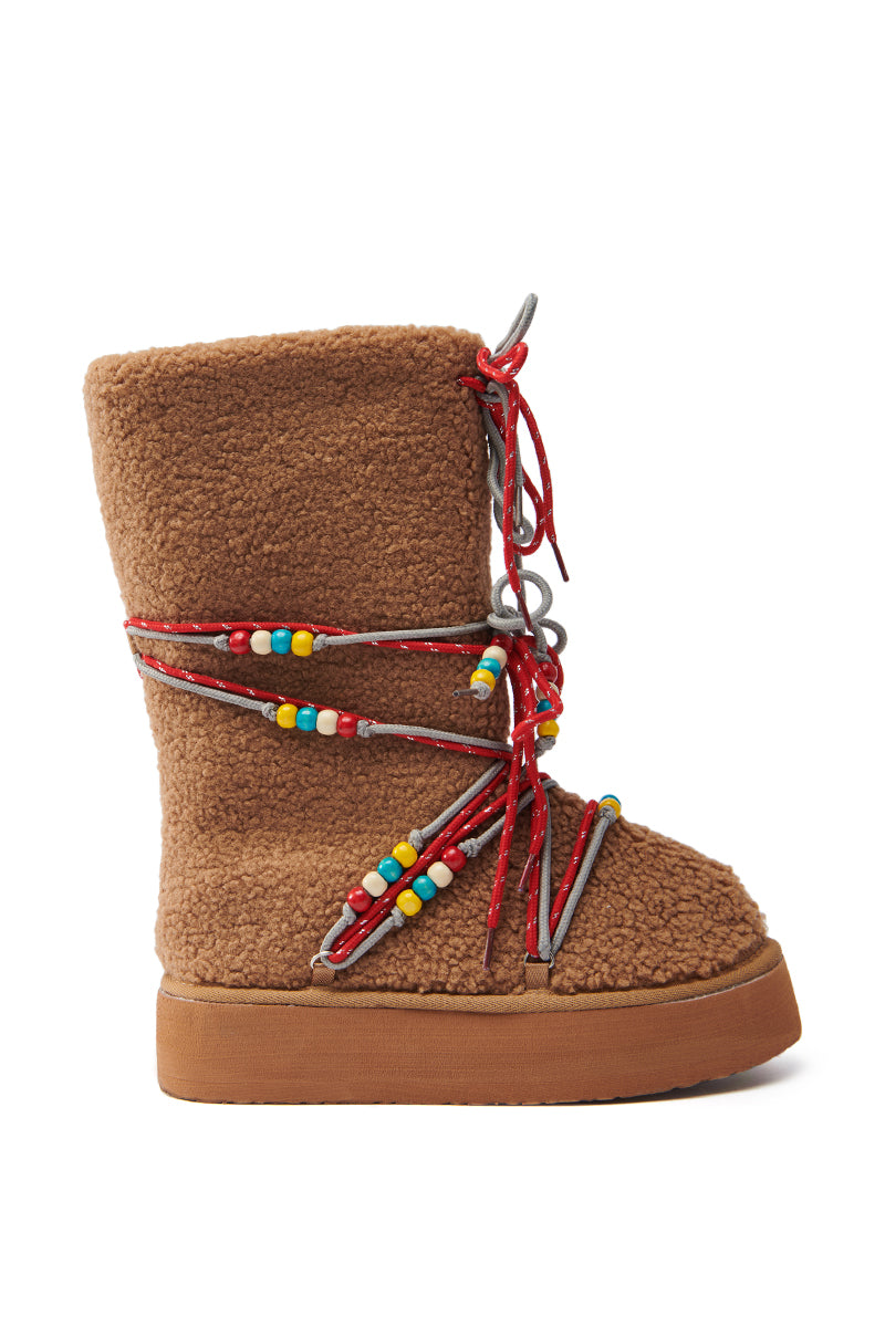 The TIGHTROPES CHESTNUT SHERPA WITH BEADS FLAT BOOTIE showcases a faux sherpa upper, high-top design, and thick flatform sole. It features red and gray laces with colorful bead accents in the side view of the left boot.