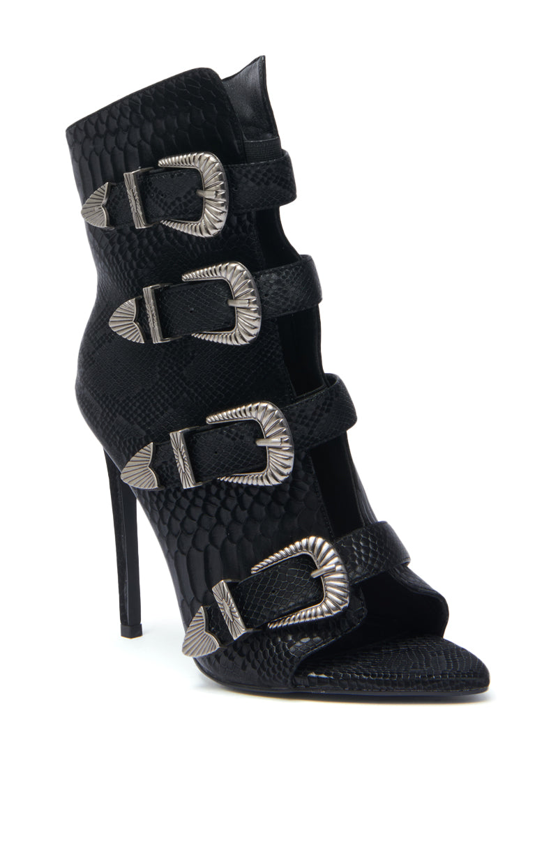 The AZALEA WANG TJEERD BLACK WESTERN BUCKLE OPEN TOE BOOTIE features a stiletto heel, open toe, snakeskin print, and four silver buckles along the front.