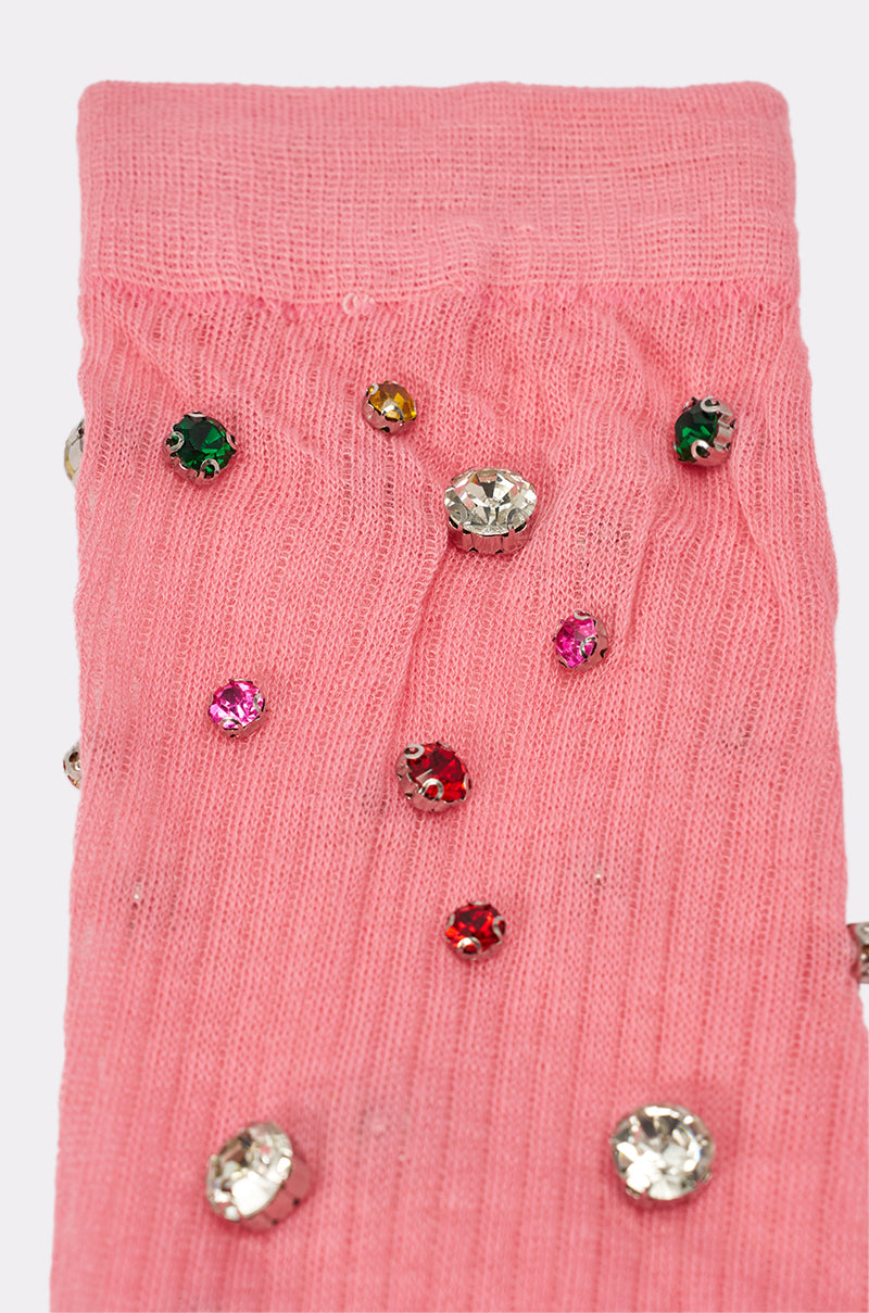 A close-up of COMPLETE THE LOOK EMBELLISHED SOCKS: pink ribbed knee-highs adorned with colorful rhinestones—green, yellow, red, pink, and clear—ideal for those who love bold statement accessories. 5